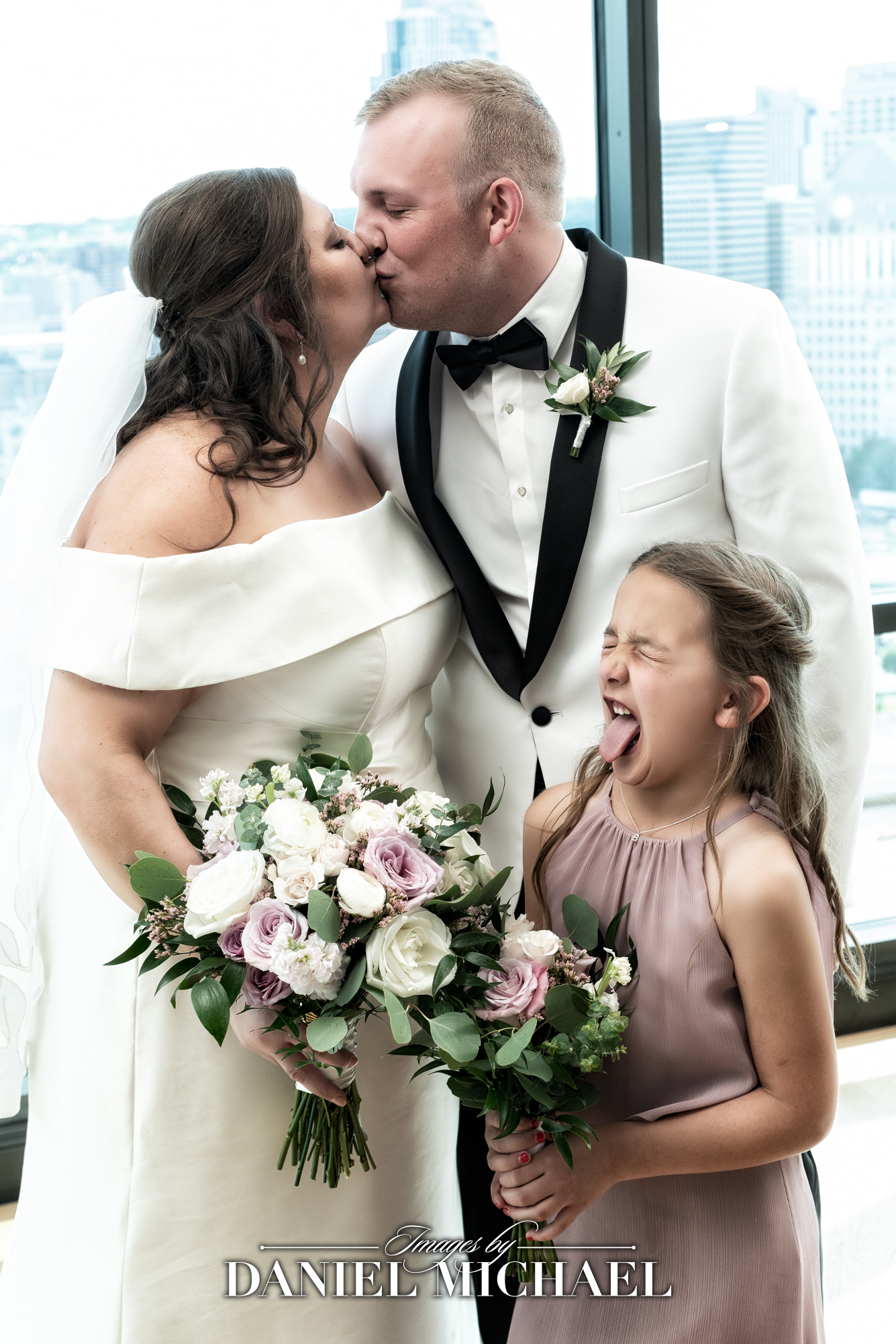 Wedding Couple Kissing with Kid making funny face